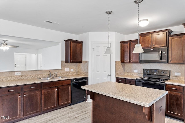 kitchen featuring ceiling fan, sink, black appliances, light hardwood / wood-style floors, and hanging light fixtures