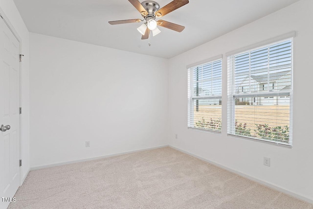 carpeted spare room featuring ceiling fan