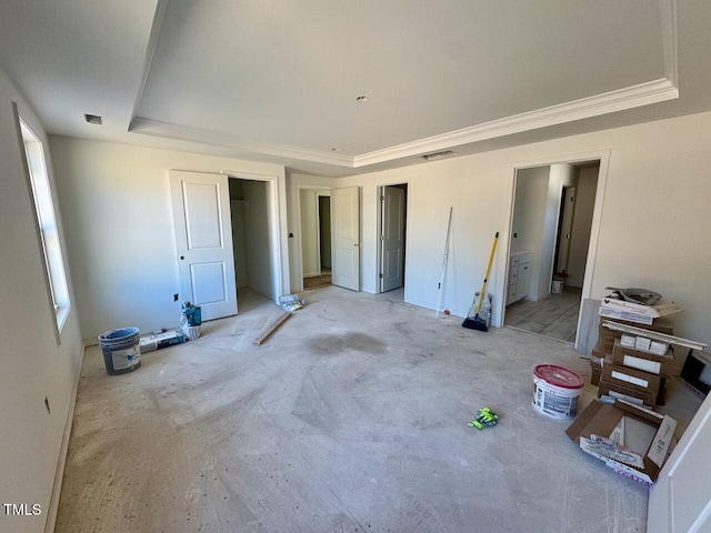 bedroom featuring ensuite bath and a tray ceiling