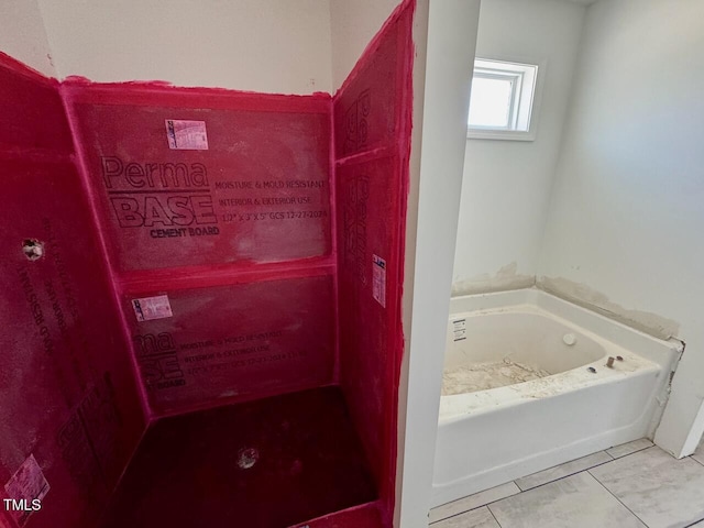 bathroom featuring tile patterned flooring and a tub