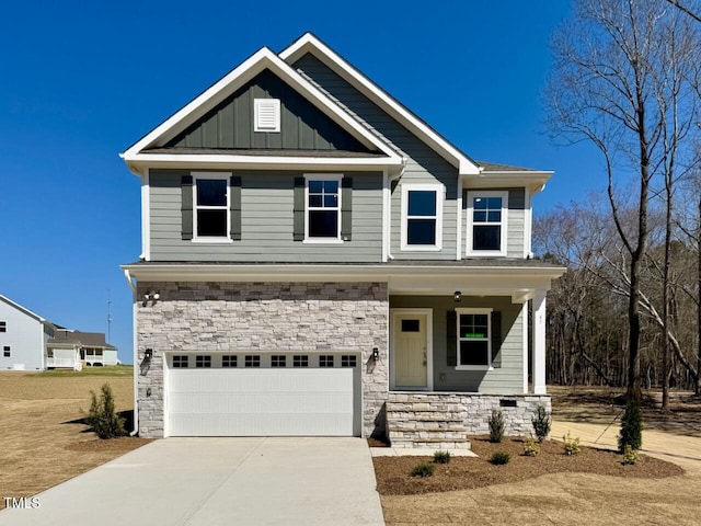 craftsman-style home with driveway, stone siding, covered porch, board and batten siding, and an attached garage