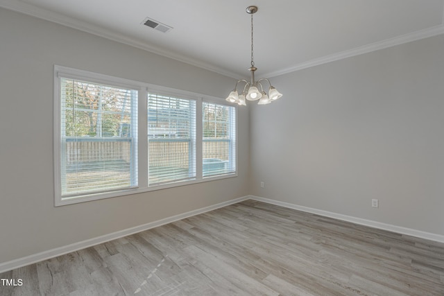 empty room featuring crown molding, a chandelier, and light hardwood / wood-style flooring