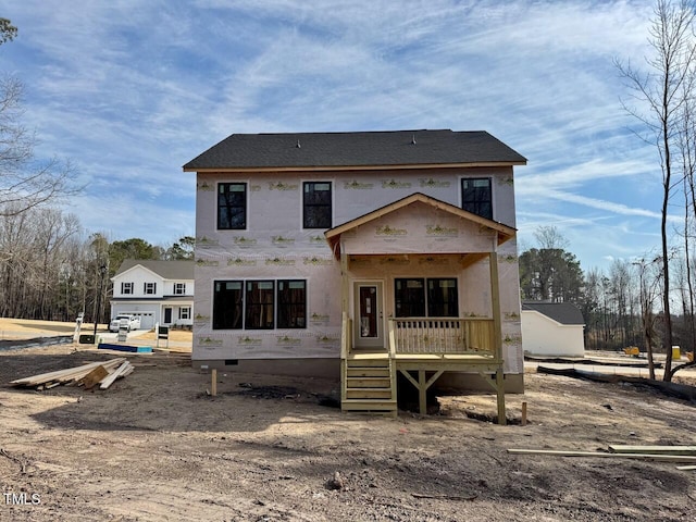 back of house featuring a garage and covered porch