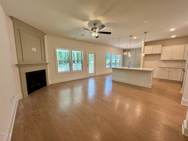 262 Grand Griffon Way, Lillington, NC 27546 - unfurnished living room with light wood finished floors, a ceiling fan, a fireplace, and recessed lighting