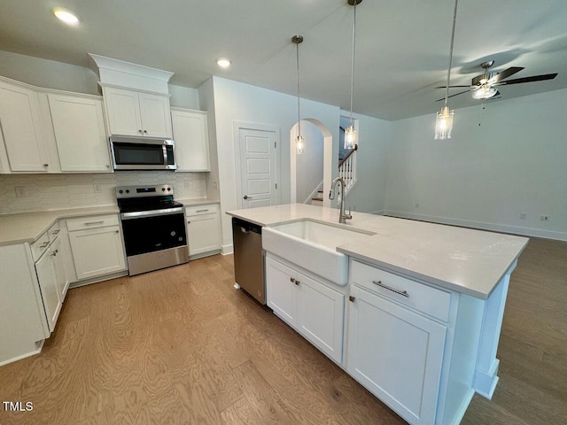262 Grand Griffon Way, Lillington, NC 27546 - kitchen featuring appliances with stainless steel finishes, a ceiling fan, tasteful backsplash, white cabinets, and pendant lighting