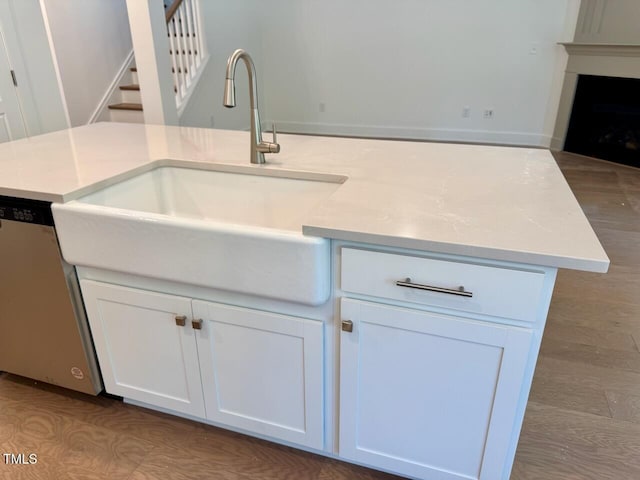 262 Grand Griffon Way, Lillington, NC 27546 - kitchen with stainless steel dishwasher, white cabinetry, light countertops, and a fireplace