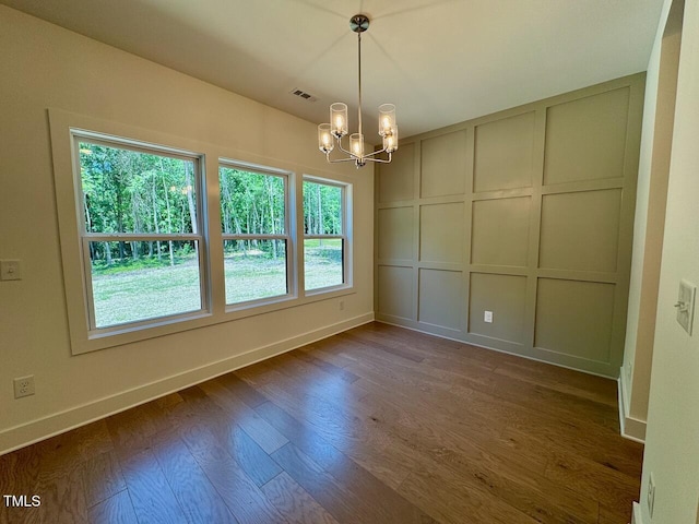 262 Grand Griffon Way, Lillington, NC 27546 - spare room featuring a decorative wall, a chandelier, and dark wood finished floors
