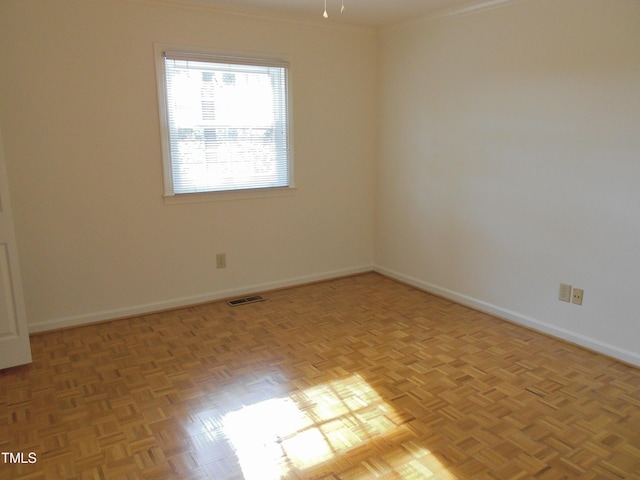 unfurnished room featuring light parquet floors and ornamental molding