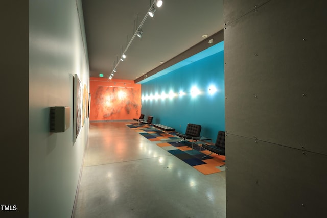 interior space featuring finished concrete flooring and track lighting