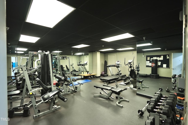 workout area with baseboards and a drop ceiling