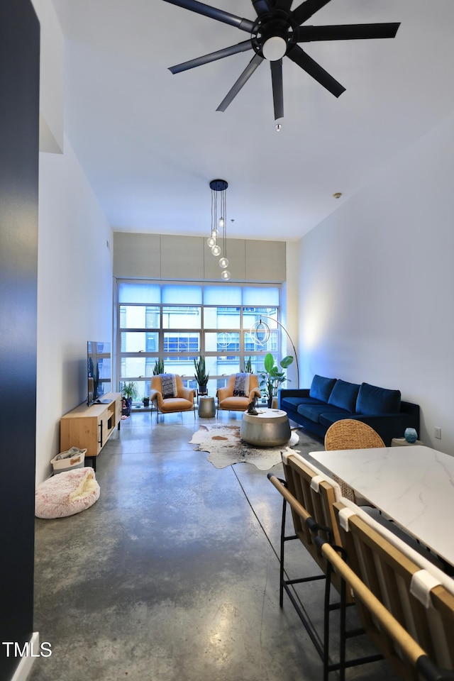 living area with concrete flooring and a ceiling fan