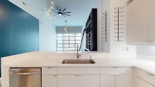 kitchen with dishwasher, light countertops, a sink, and white cabinets