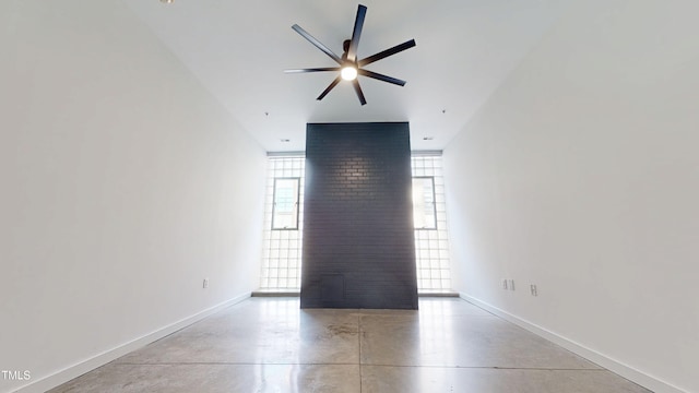 empty room with a ceiling fan, finished concrete flooring, and baseboards