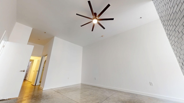 unfurnished room featuring ceiling fan, finished concrete flooring, and baseboards