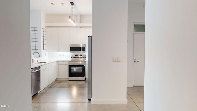 kitchen featuring stainless steel appliances, a sink, white cabinetry, hanging light fixtures, and light countertops