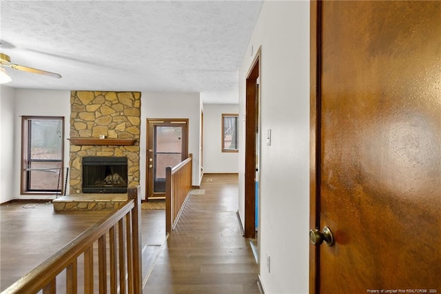 hall with a textured ceiling and dark hardwood / wood-style floors