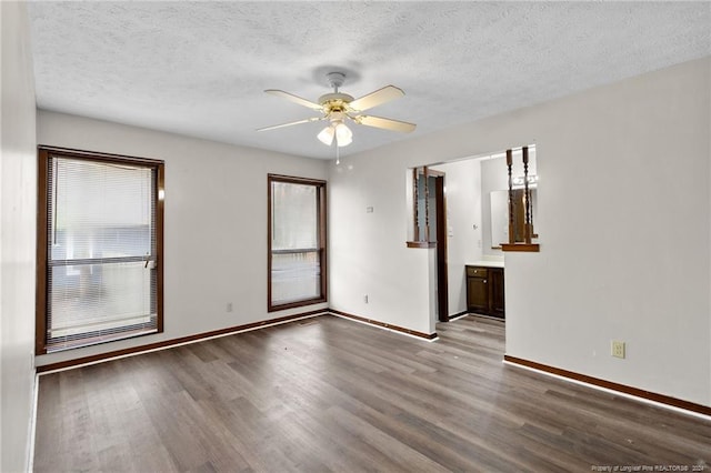 unfurnished room with ceiling fan, a healthy amount of sunlight, light wood-type flooring, and a textured ceiling