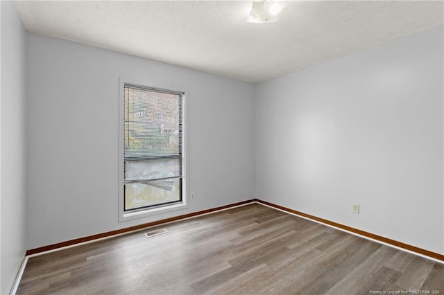 spare room with hardwood / wood-style flooring and a textured ceiling