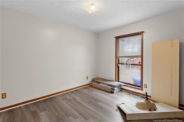 spare room featuring a textured ceiling and hardwood / wood-style flooring