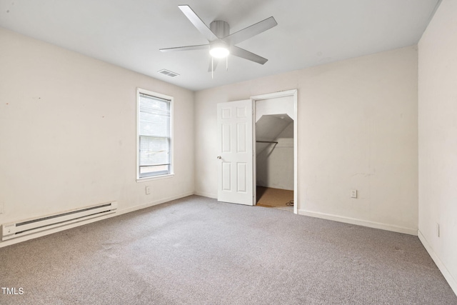 unfurnished bedroom featuring carpet flooring, ceiling fan, a baseboard radiator, a spacious closet, and a closet