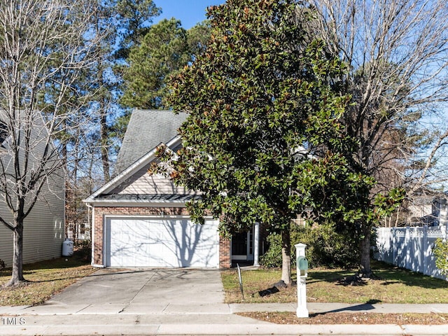 view of property hidden behind natural elements featuring a garage