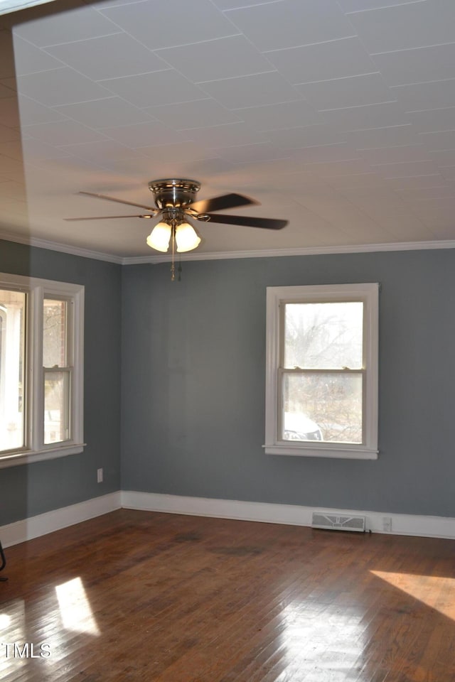 spare room featuring dark hardwood / wood-style floors, a wealth of natural light, crown molding, and ceiling fan