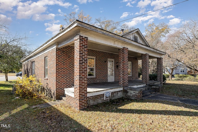 view of front of house featuring covered porch and a front yard