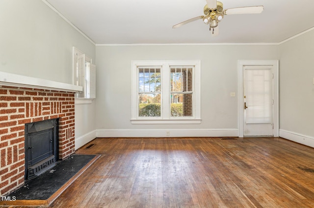 unfurnished living room featuring dark hardwood / wood-style floors, a brick fireplace, ceiling fan, and crown molding