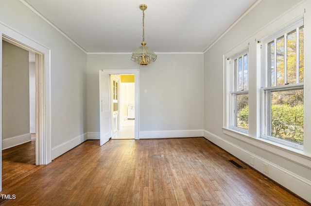 unfurnished room featuring hardwood / wood-style flooring, crown molding, and an inviting chandelier