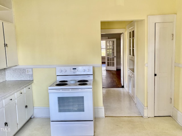 kitchen featuring white electric range oven and white cabinets