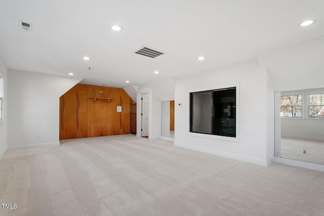 unfurnished living room featuring lofted ceiling and light carpet