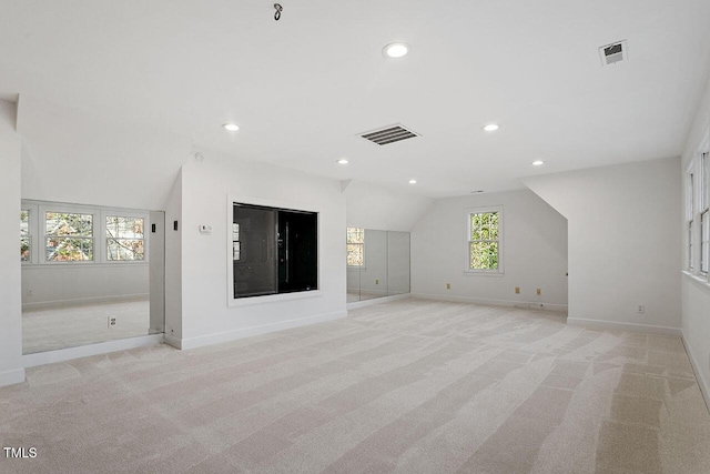 unfurnished living room with light carpet and lofted ceiling