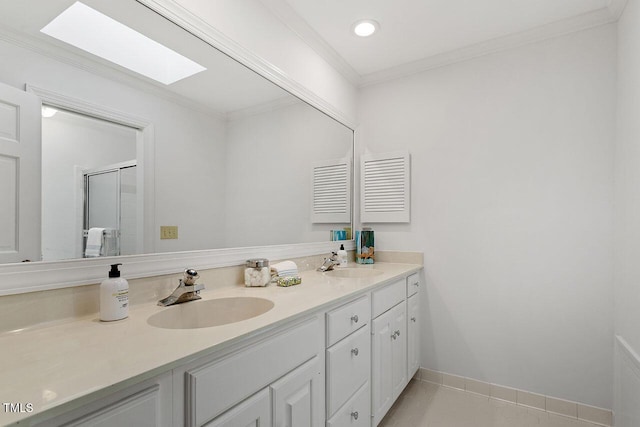 bathroom featuring tile patterned floors, a skylight, crown molding, and vanity