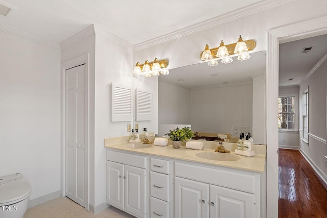 bathroom featuring toilet, vanity, ornamental molding, and hardwood / wood-style flooring