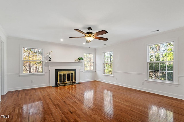 unfurnished living room featuring hardwood / wood-style floors, ceiling fan, a healthy amount of sunlight, and ornamental molding