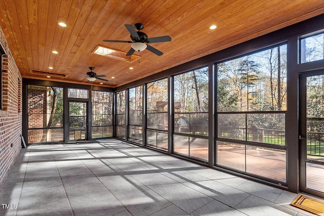 unfurnished sunroom with ceiling fan, wooden ceiling, and a skylight