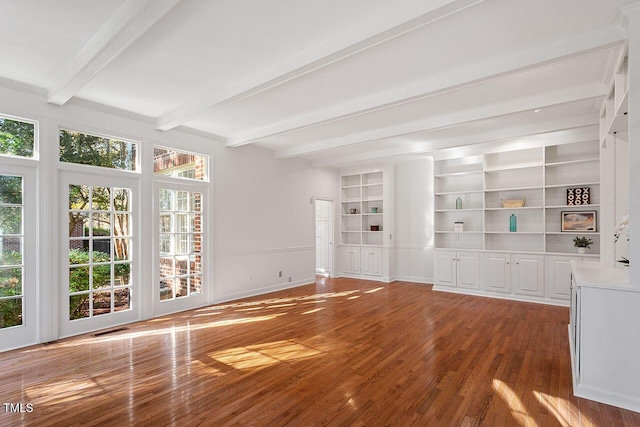 unfurnished living room with hardwood / wood-style flooring, built in shelves, and beam ceiling