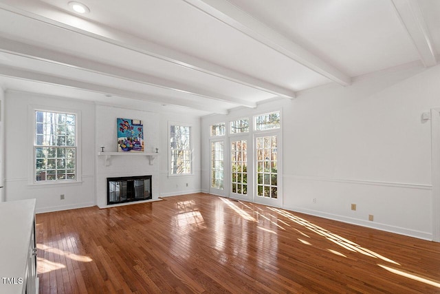 unfurnished living room with beam ceiling, a fireplace, and hardwood / wood-style flooring