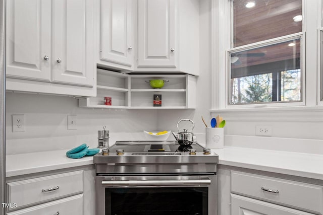 kitchen with stainless steel stove and white cabinetry