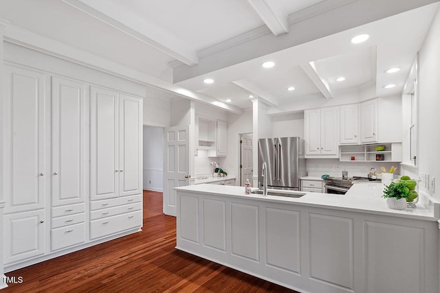 kitchen with beam ceiling, white cabinetry, stainless steel appliances, dark hardwood / wood-style flooring, and kitchen peninsula