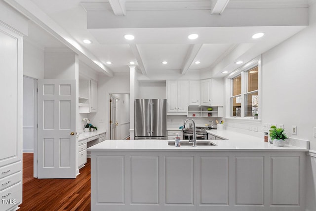 kitchen with stainless steel refrigerator, kitchen peninsula, dark wood-type flooring, and sink