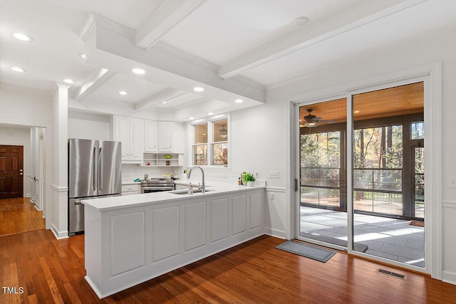 kitchen featuring kitchen peninsula, white cabinetry, dark hardwood / wood-style floors, and appliances with stainless steel finishes