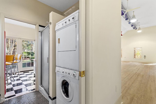 clothes washing area featuring stacked washer and dryer and light hardwood / wood-style floors