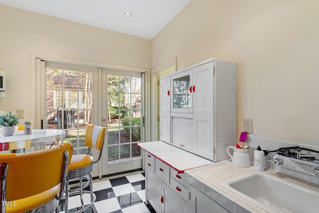 kitchen featuring white cabinetry and sink