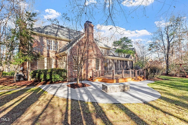 back of house with a sunroom, a lawn, a patio area, and a wooden deck