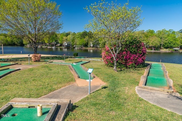 view of property's community with a water view and a lawn