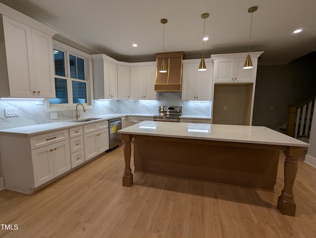 kitchen with appliances with stainless steel finishes, white cabinetry, and decorative light fixtures