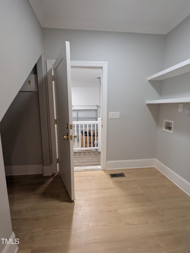 washroom with hardwood / wood-style flooring and hookup for a washing machine