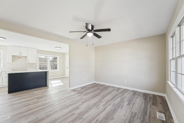 unfurnished living room with light hardwood / wood-style flooring and ceiling fan