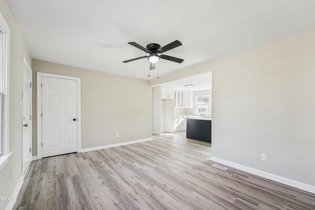 interior space featuring ceiling fan, sink, and light hardwood / wood-style flooring